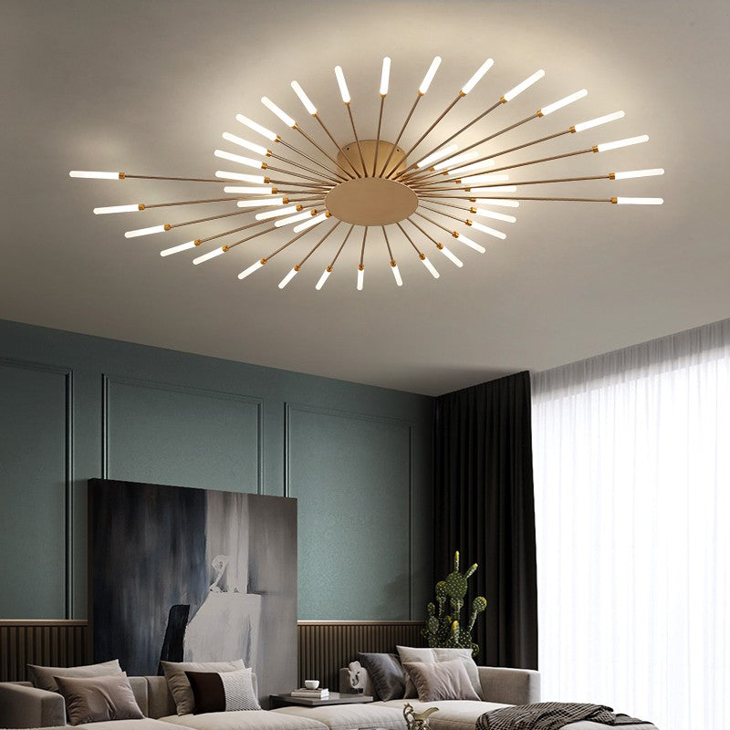 A ceiling mounted LED chandelier with a warm white light, featuring a gold and white acrylic design with multiple protruding light elements, installed in a room with a high ceiling.