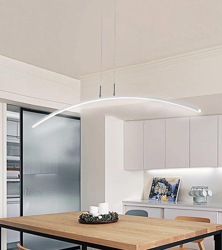 Modern LED pendant light with a curved design in white color, installed over a dining table in a scandinavian interior.