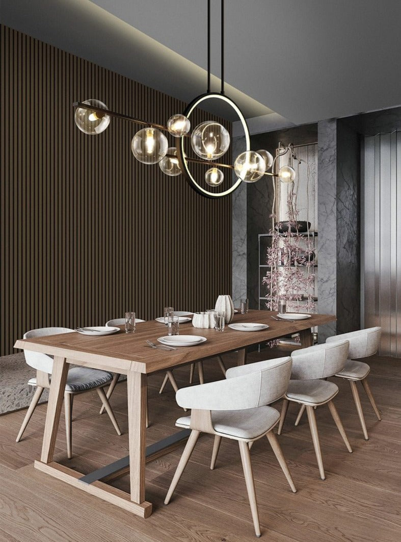 Modern pendant light with glass globes and a circular LED ring above a food table.